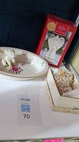 Lenox elephant figurine sitting on Lenox floral decorative plate next to Lenox angel ornament box and patterned glass elephant figurine in separate box.