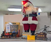 Full lot photo showing light up moving Santa, light up train set, and San Francisco puzzle box
