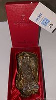 Crystal angel figurine in red box with gold tissue paper, showing brand and series on box lid.