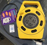 Photo of the yellow Woods Power Caddy+ 25 ft extension cord with four receptacles and carrying handle.