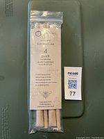 Package of 4 beeswax candling cones in clear plastic bag with product info and branding visible.