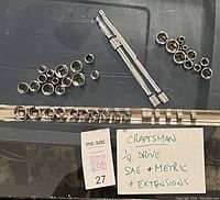 Photo showing Craftsman brand 1/4 inch drive sockets in SAE and Metric sizes alongside three socket extensions laid out neatly on black background with a label.