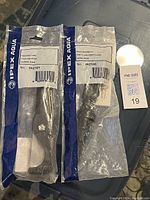 Two IPEX branded pipe tools in unopened plastic packaging laid flat on a surface, tagged with a lot number.