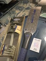 Marples Japanese style pull saw displayed outside its plastic packaging on a black surface, showing the full blade and handle, alongside a MaxSold tag marked 25.