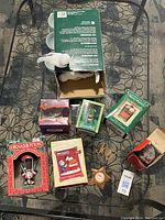 Full lot of Christmas tree ornaments displayed on table including boxes and loose ornaments.