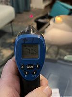 Front view of the Mastercraft infrared thermometer showing digital temperature reading 70.5°F with control buttons visible.