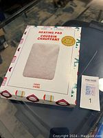 Front view of the box showing the ivory heating pad inside and packaging details.
