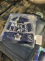 Photo of the new Toronto Maple Leafs touque sealed in plastic packaging showing front logo and design details.