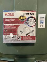 Two sealed boxed Kidde Pro Series direct wire 120V smoke and carbon monoxide alarms with front-loading battery backups and Hush buttons.