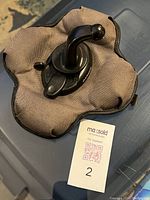 Weighted fabric-covered GPS holder with Garmin-branded black mount arm on top, shown from one angle