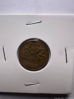 Reverse side of 1965 Canadian 1 cent coin with maple leaf design and inscriptions.