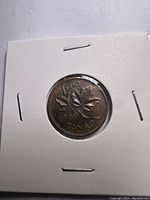 Front view of the coin showing the reverse with two maple leaves and inscriptions 1 CENT 1969 CANADA, inside a white cardboard holder.