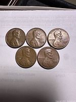 Obverse side of five Lincoln Memorial Penny coins dated 1972, 1973, 1974, 1976, and 1978 showing Abraham Lincoln bust.