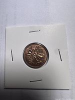 Reverse side of the 1974 Canadian 1 cent coin showing maple leaves and inscriptions.