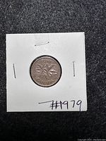 Reverse side of the 1979 Canadian one cent coin showing the maple leaves design and denomination.