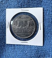 Front side of the coin showing 1867 Confederation and 1982 Constitution design with people and arches