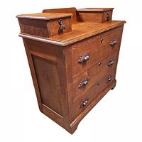 Side angled view showing the carved drawer pulls, lock plates on top compartments, and wood grain.