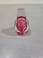 Front view of the thick glass vase with a red sphere inside, showing its shape and coloration.