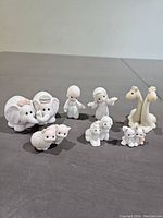 Photo showing the full set of 10 Precious Moments Noah's Ark figurines including pairs of animals and two human figures (Noah and his wife).