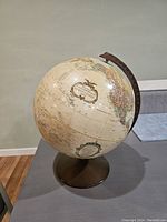 Photo of the Replogle globe showing the Pacific Ocean side with vintage-style cartography and cream-colored ocean