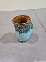 Front angled view of the pottery mug showing the glaze colors and shape