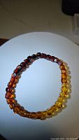 Top-down view of Baltic amber bracelet showing natural color gradient from dark amber to yellow.