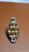 Front view of ring showing multiple oval natural golden citrine stones in cluster setting on rhodium plated 925 sterling silver band.