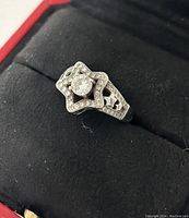 Close-up angled view of the silver star-shaped ring showing the central round gemstone and surrounding clear stones with star cut-outs on the band.