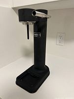 Front side view of Aarke carbonator soda maker showing black body and stainless steel nozzle.