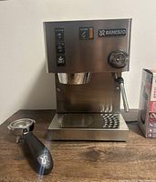 Front view of Rancilio Silvia espresso machine with portafilter detached on counter