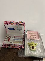 Watch box open showing watch and colored straps inside, focus on contents and box design