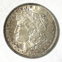 Obverse side of a 1879 Morgan Silver Dollar coin showing Lady Liberty and date.