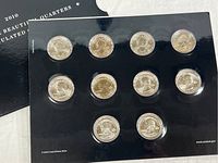 Black plastic holder with 10 uncirculated America The Beautiful quarters from 2010, each quarter visible and sealed.