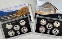 Both 2014 and 2015 America The Beautiful Silver Quarter Proof Sets with cardboard folders and plastic coin cases containing quarters.