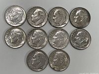 Top side view showing obverse of 10 Roosevelt dimes with dates from 1950 to 1964 and profile of Franklin D. Roosevelt.