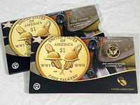 Two 2016 American $1 Code Talkers Coin & Currency sets from the U.S. Mint in original cardboard sleeves, front view.