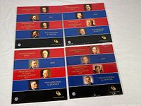 Four sealed U.S. Mint Presidential $1 Coin Uncirculated Sets laid out showing 2011, 2012, 2014, and 2015 dates on front covers.