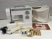 Bernette Model 705 sewing machine with vinyl carrying case, foot pedal, manual, original box, and several small accessories organized in containers.
