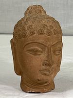 Front view of the vintage cast ceramic Buddha head sculpture showing detailed curls and facial features.