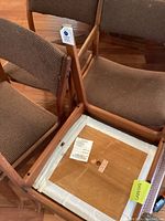 Underside of a side chair showing broken seat frame and label