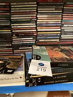 Stack of CDs with opera titles visible such as Carmen, Tosca, La Bohème, Madama Butterfly and other assorted CDs.