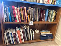 Books on the two shelves including both hardcover and paperback books with titles mainly about WWII and Holocaust survivor stories