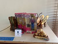 Four Happy Together dolls in packaging with two wooden pull toys and a wooden puzzle on carpeted floor near a window blind.