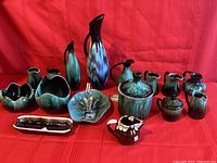 Front view of full set showing all Blue Mountain Pottery items arranged on red fabric background