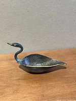 Side angle of brass swan goose ashtray showing detailed feather texture and curved neck