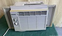 Front view of Danby window air conditioner showing main grille and control knobs, with side accordion panels extended