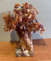Front view of amber tree sculpture showing copper-toned wire branches with amber stone chips and textured trunk on marble base.