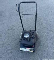 Front view of Coleman Powermate 2000 PSI pressure washer showing handle, engine, and base unit branding.