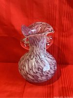 Front angle view of the vintage glass vase showing mottled purple-white color and clear handles.