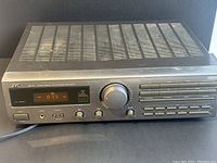 Front and top view of vintage JVC RX-315 receiver showing control panel, digital display, and ventilation grilles with some wear and dust.